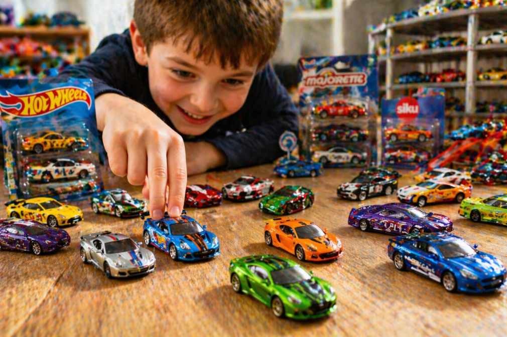 dítě si hraje s Hot Wheels Majorette a Siku malými kovovými autíčky a závodí s nimi po podlaze