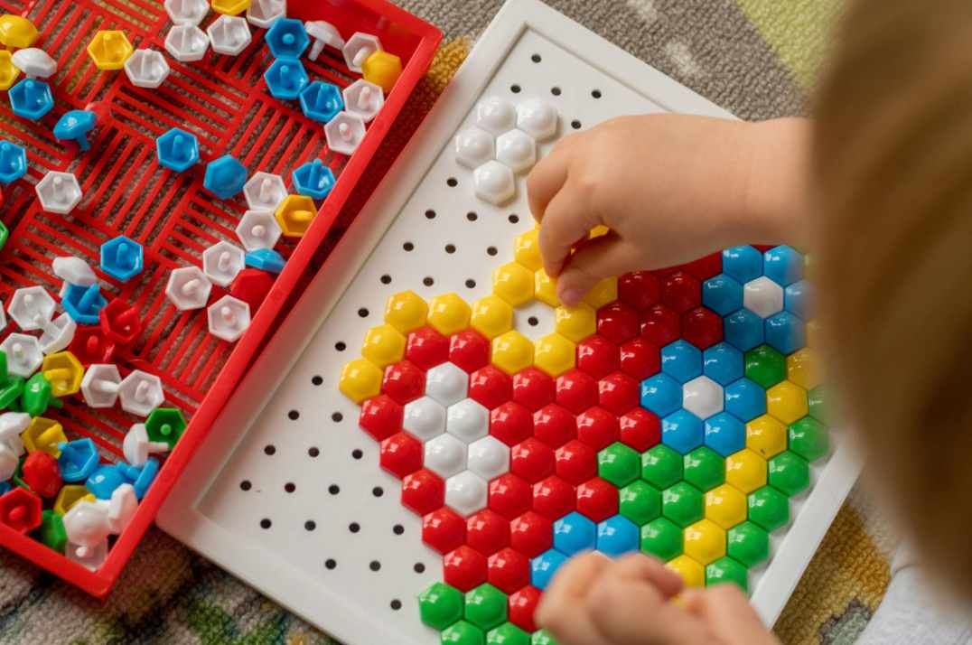 dítě skládá barevnou mozaiku z dílků