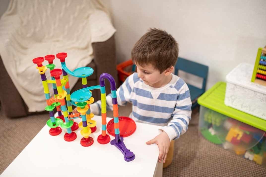 dítě staví kuličkovou dráhu a sleduje kuličky