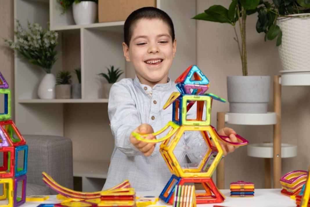 dítě staví z magnetické stavebnice barevné tvary