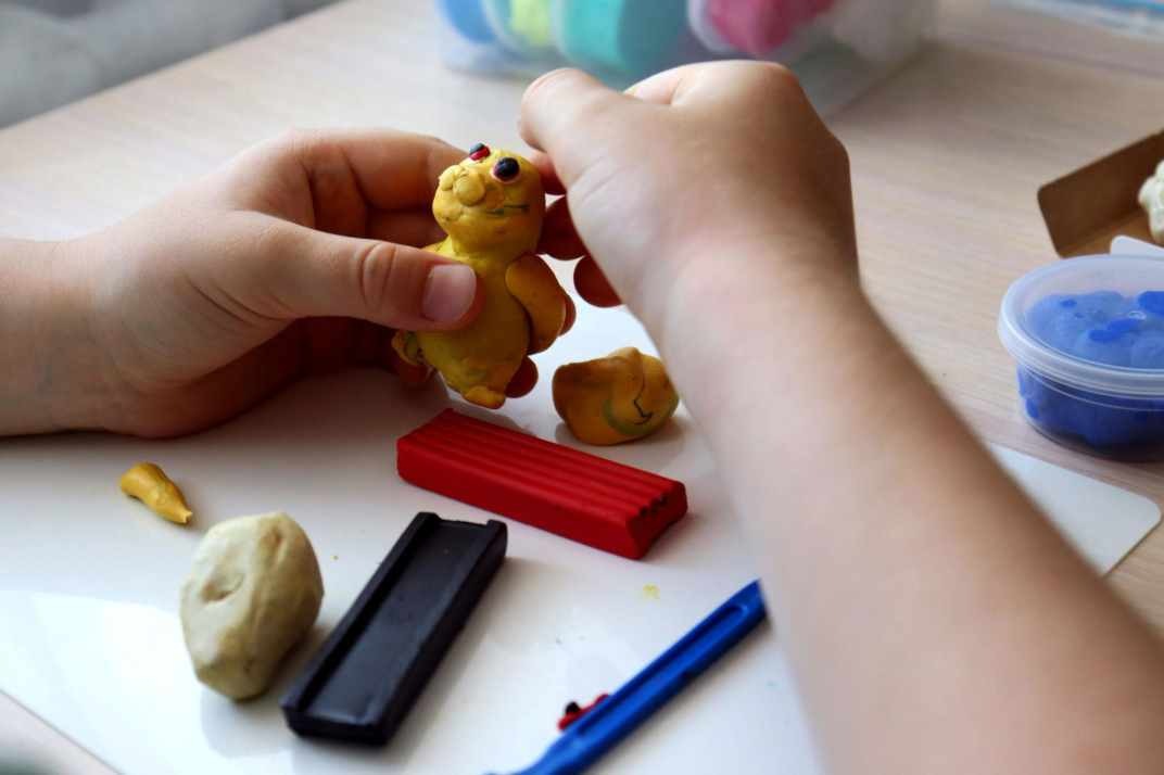 dítě tvoří postavičky z plastelíny a modelovací hmoty